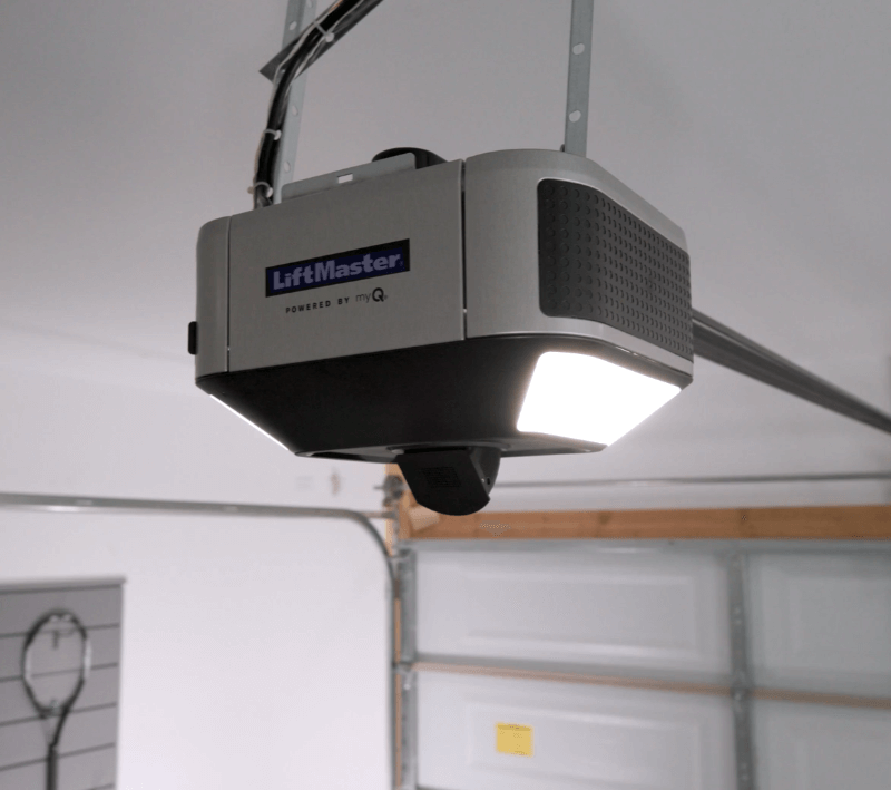 A LiftMaster garage door opener powered by MyQ affixed to a garage ceiling.