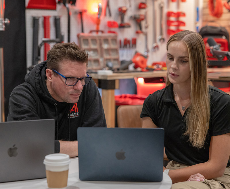 Two A1 team members at laptops